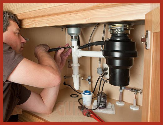 Certified plumber mounting a new garburator under a kitchen sink