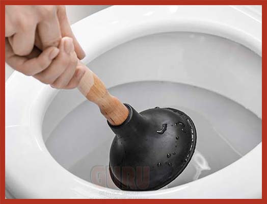 Experienced plumber using a plunger to fix a water closet
